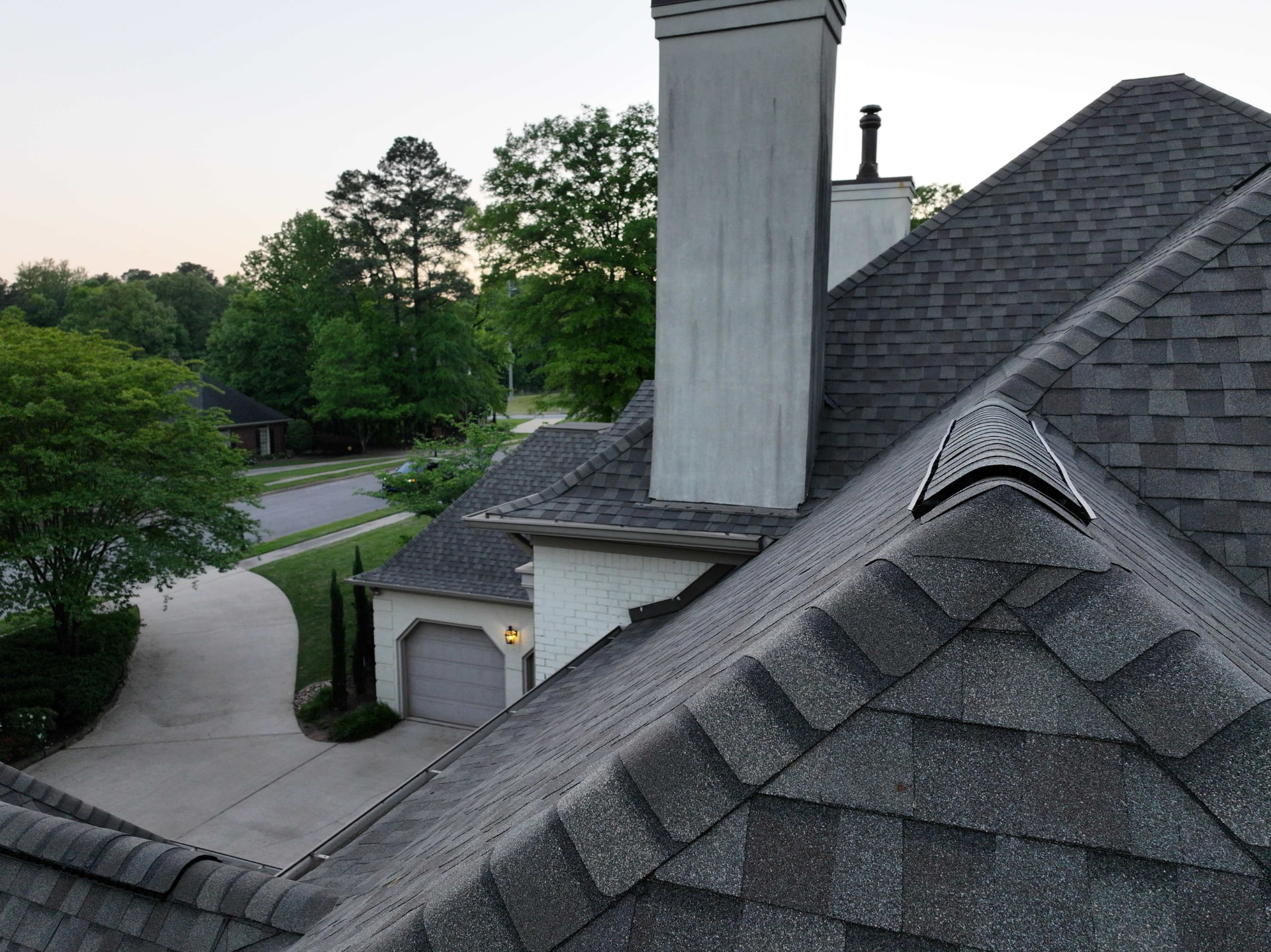 Close-up of ridge cap shingles and roof vent on a finished roof