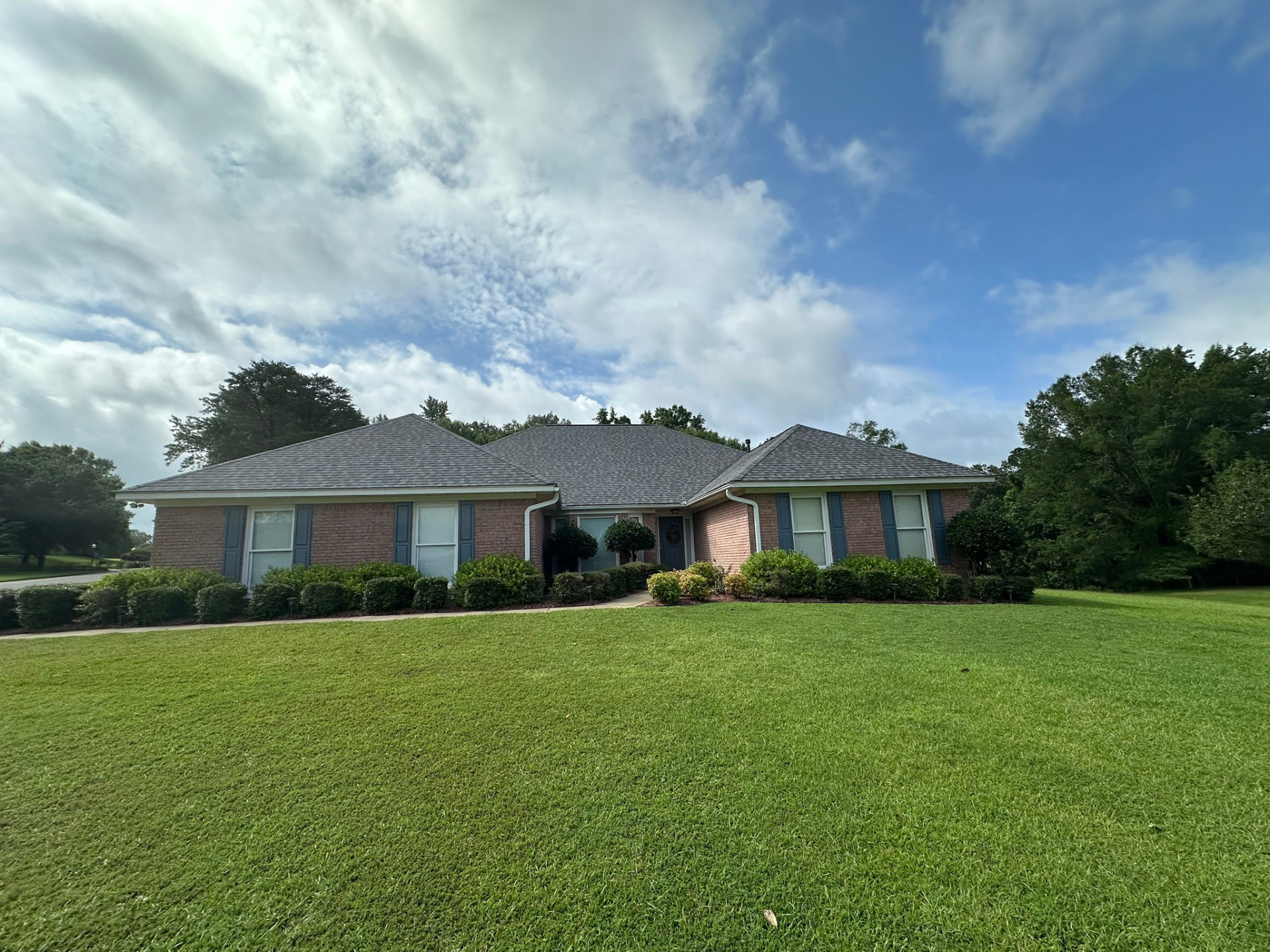 Completed gray asphalt shingle roof on a single-story brick home